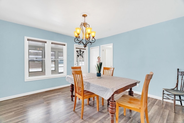 dining area with a notable chandelier and dark hardwood / wood-style flooring