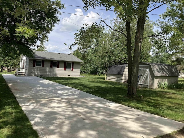 view of front of property with a storage shed and a front lawn