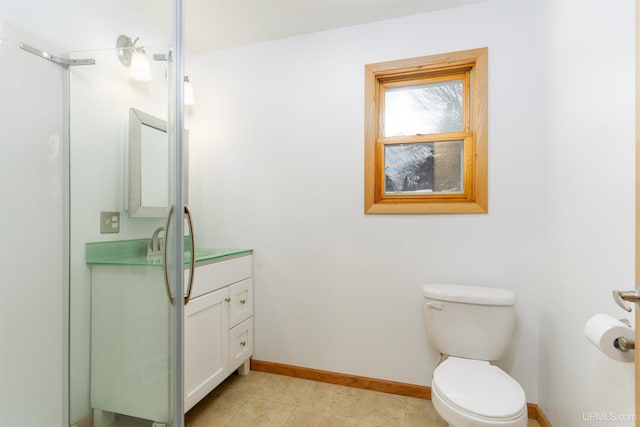 bathroom featuring baseboards, vanity, toilet, and tile patterned floors