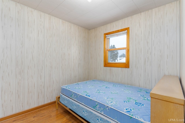 bedroom with baseboards and wood finished floors