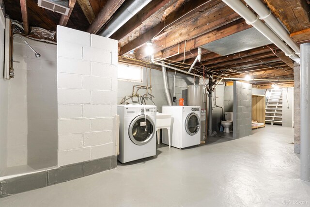 below grade area with washing machine and dryer, visible vents, and water heater