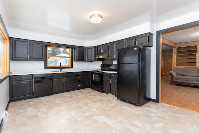 kitchen featuring black appliances, under cabinet range hood, light countertops, and a sink