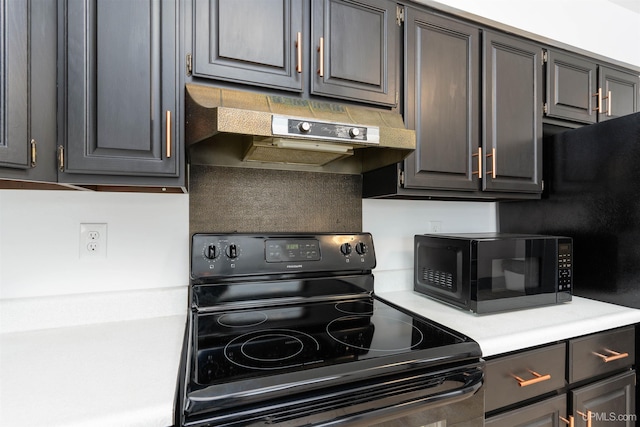 kitchen featuring black appliances, under cabinet range hood, and light countertops