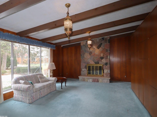 living room with a fireplace, light carpet, a wealth of natural light, and wood walls