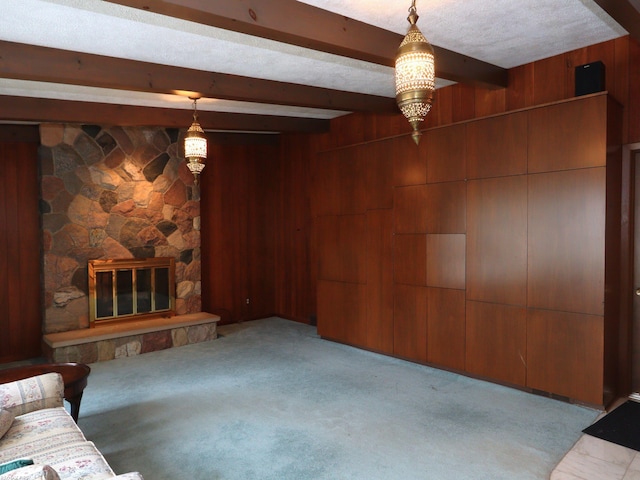 unfurnished living room featuring light carpet, a fireplace, beamed ceiling, and a textured ceiling