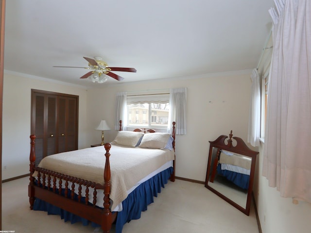 bedroom featuring ceiling fan, ornamental molding, light carpet, and a closet