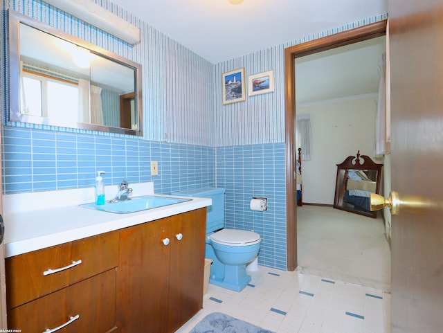 bathroom with tile patterned floors, vanity, tile walls, and toilet