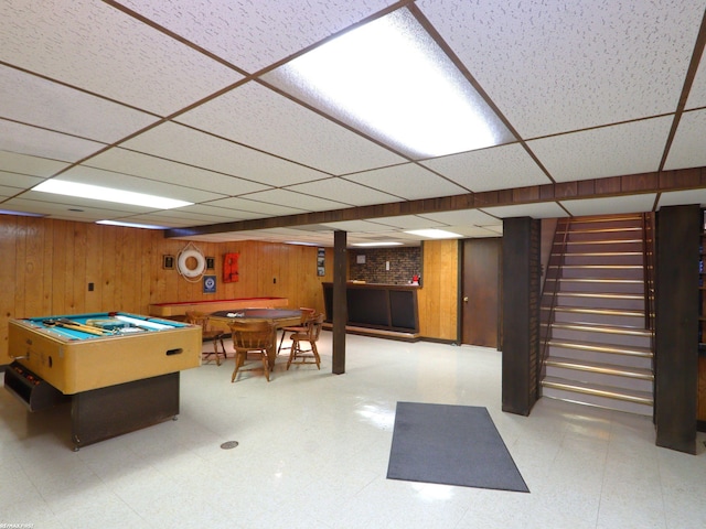 recreation room with a paneled ceiling, wooden walls, and pool table