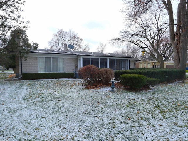 rear view of house featuring a sunroom