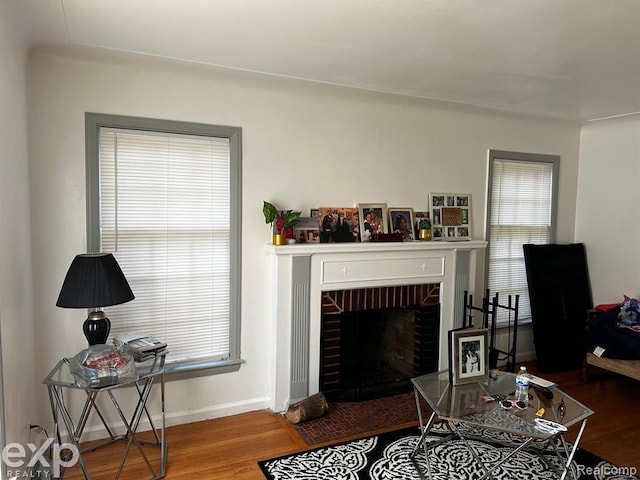 living room featuring hardwood / wood-style flooring and a brick fireplace