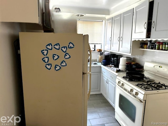 kitchen featuring backsplash, white cabinets, and white appliances