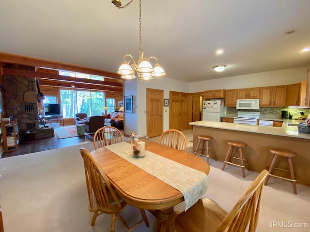 dining space with sink, light hardwood / wood-style floors, and a notable chandelier