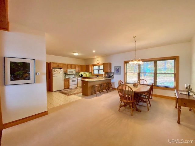 carpeted dining room with a chandelier, a healthy amount of sunlight, and sink