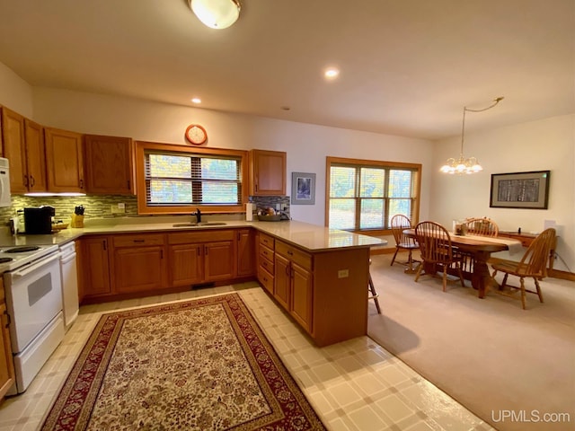 kitchen with kitchen peninsula, light carpet, sink, white electric range, and hanging light fixtures