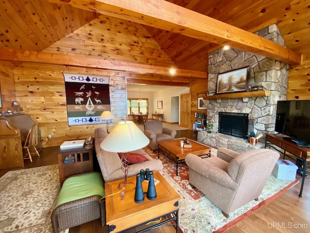 living room with a stone fireplace, wooden walls, beamed ceiling, and wood-type flooring