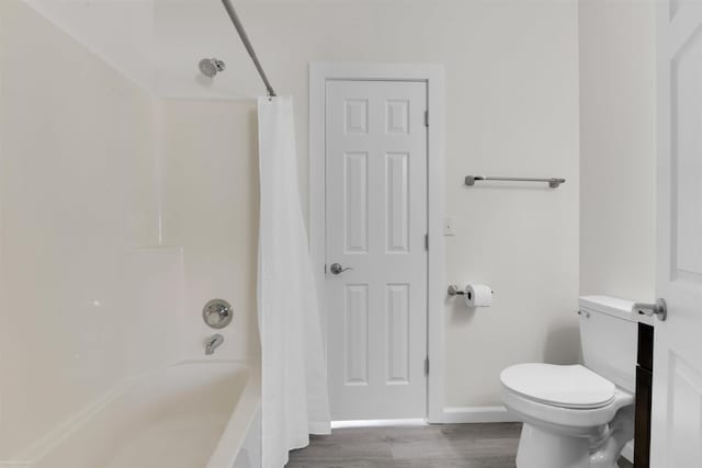 bathroom featuring shower / bath combo with shower curtain, toilet, and wood-type flooring