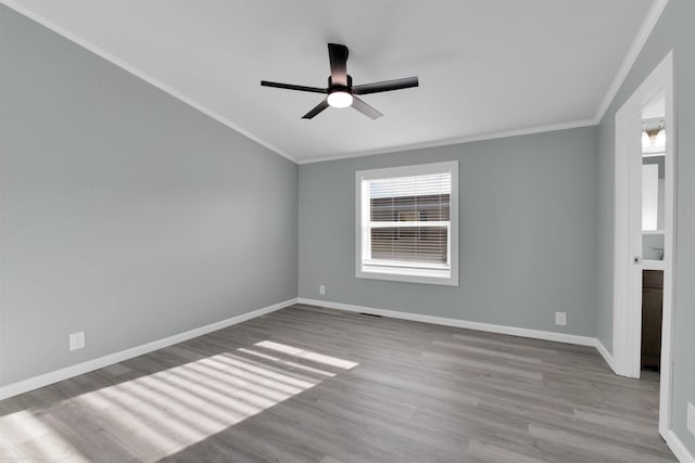 empty room with ceiling fan, crown molding, and light hardwood / wood-style flooring