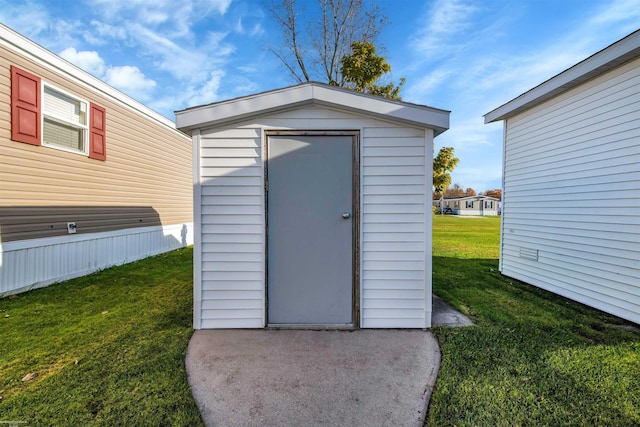 view of outbuilding featuring a lawn