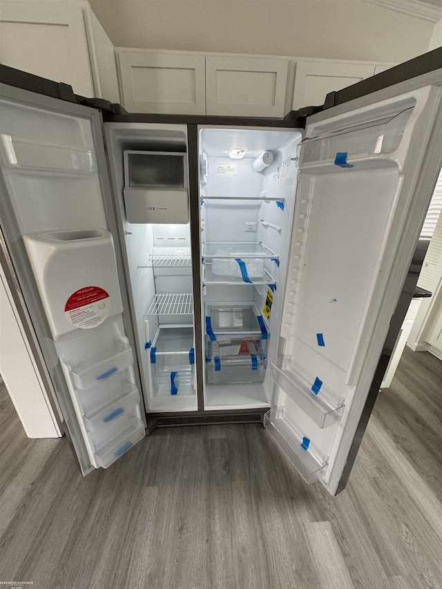 room details with hardwood / wood-style floors and white cabinetry