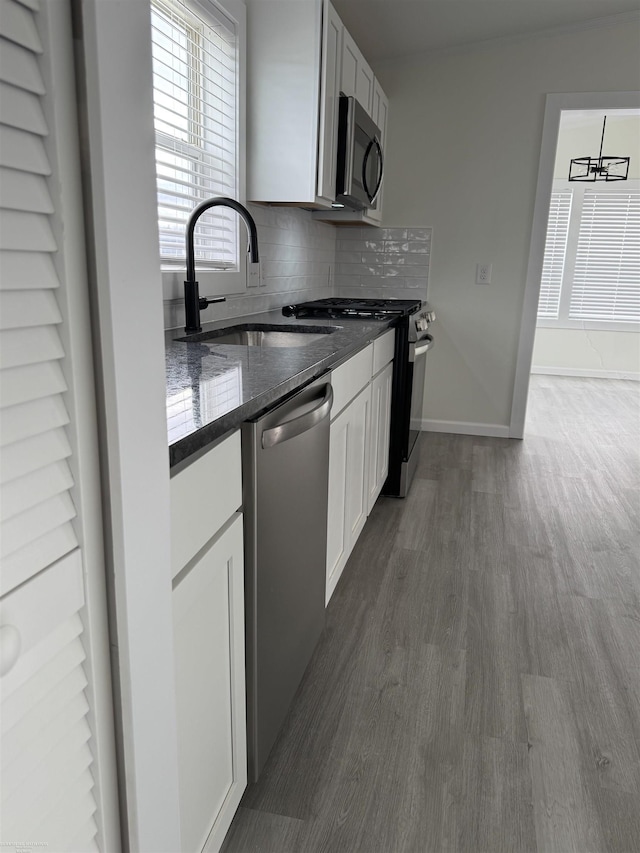 kitchen with dark wood-type flooring, sink, white cabinets, and stainless steel appliances