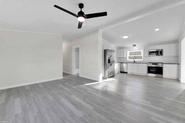 unfurnished living room featuring ceiling fan, crown molding, and light wood-type flooring