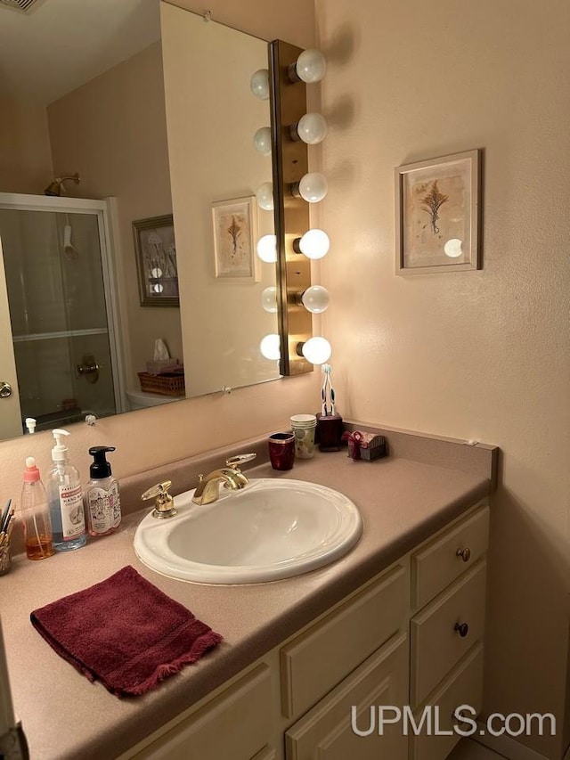 bathroom with vanity and a shower with shower door