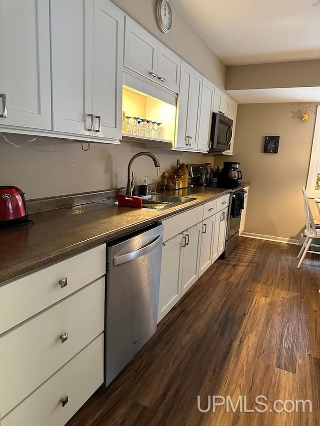 kitchen featuring sink, white cabinetry, dark wood-type flooring, and appliances with stainless steel finishes