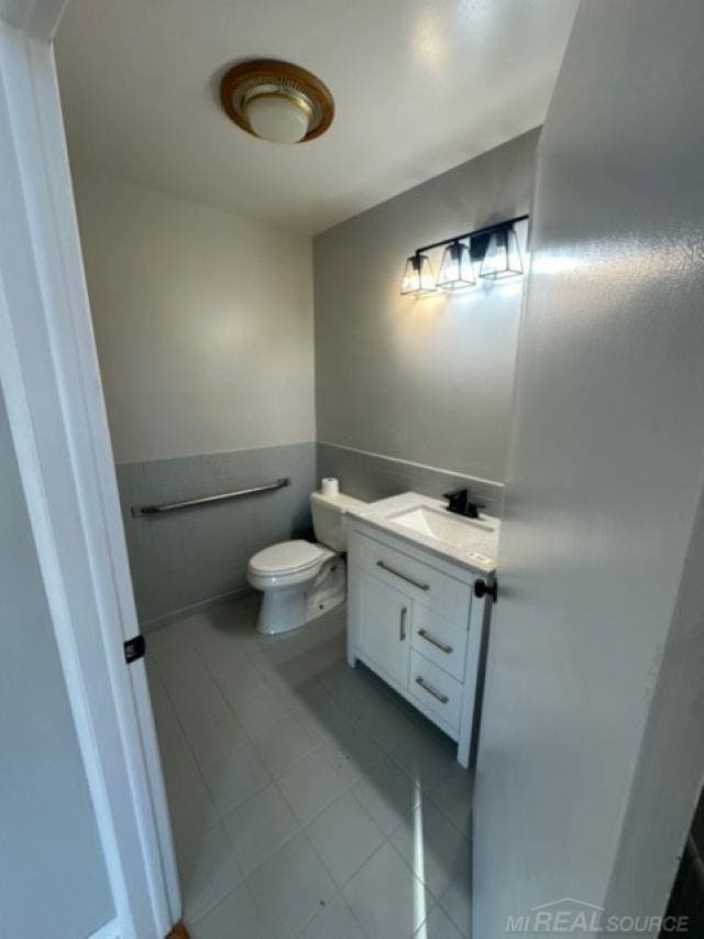 bathroom featuring tile patterned flooring, vanity, and toilet