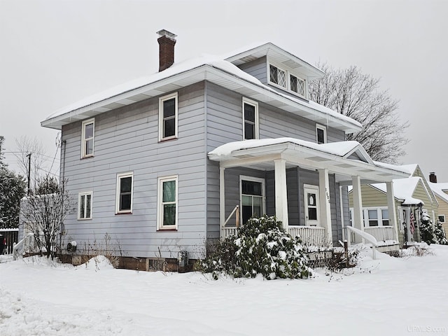 view of snow covered exterior with a porch