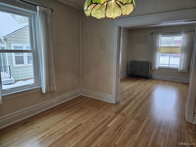 unfurnished room with radiator, light hardwood / wood-style floors, and ornamental molding