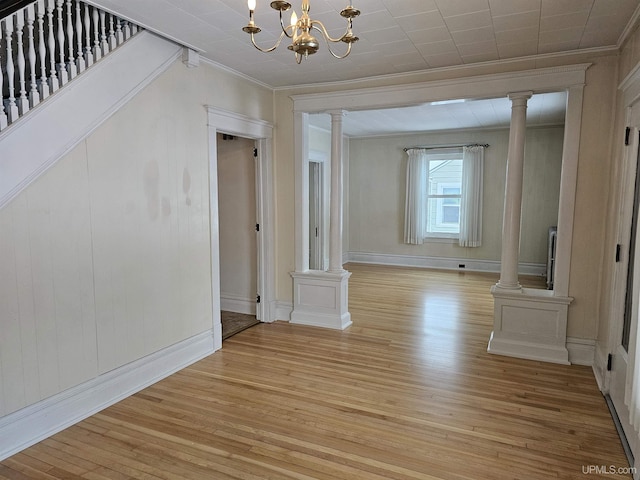 unfurnished dining area featuring light hardwood / wood-style floors, crown molding, and a chandelier