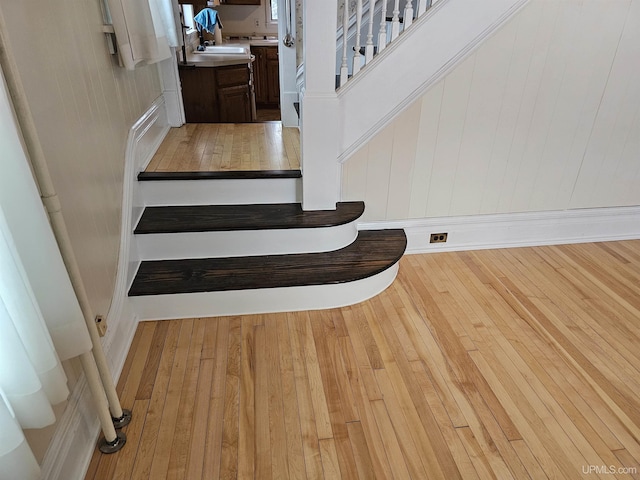 stairway featuring hardwood / wood-style floors and wooden walls