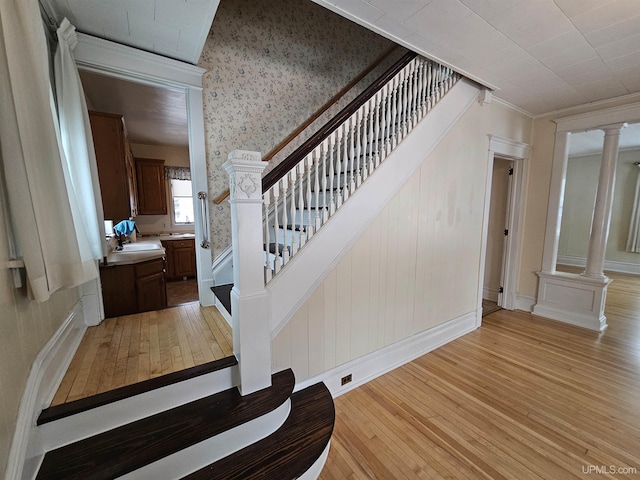 stairs with hardwood / wood-style floors and ornamental molding