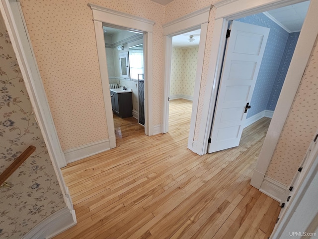 hallway featuring light hardwood / wood-style floors and ornamental molding