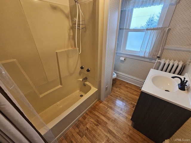 full bathroom featuring shower / bathing tub combination, vanity, radiator, hardwood / wood-style flooring, and toilet