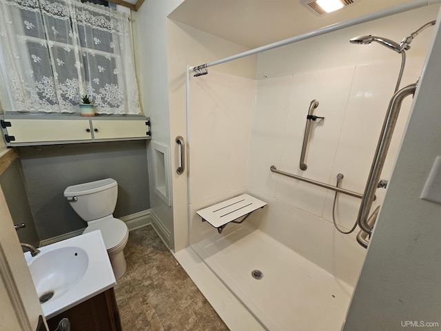 bathroom with a shower, vanity, and toilet