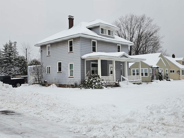 snow covered house with covered porch