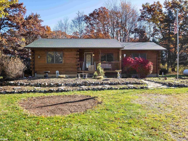 log-style house with a front yard and covered porch