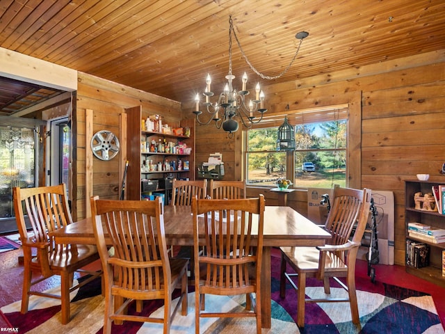 dining area featuring wood walls, wooden ceiling, and an inviting chandelier