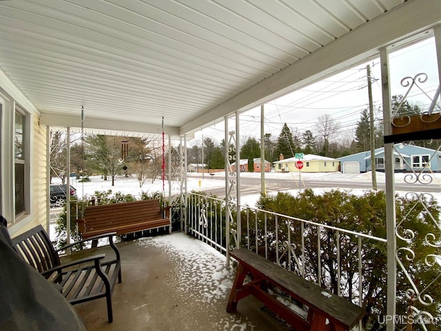 snow covered patio featuring a porch