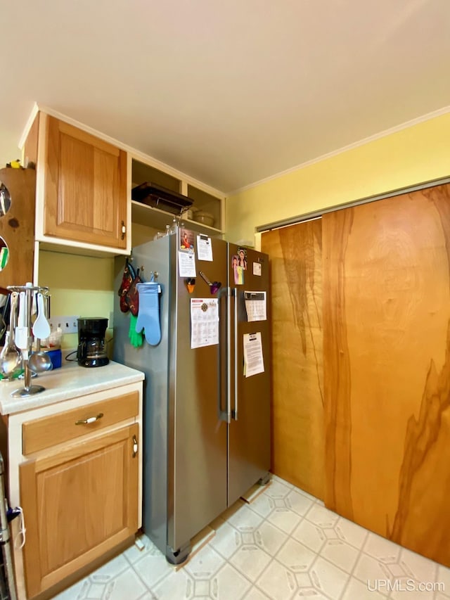 kitchen with stainless steel fridge and ornamental molding