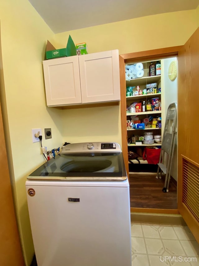 laundry room featuring cabinets and washer / dryer