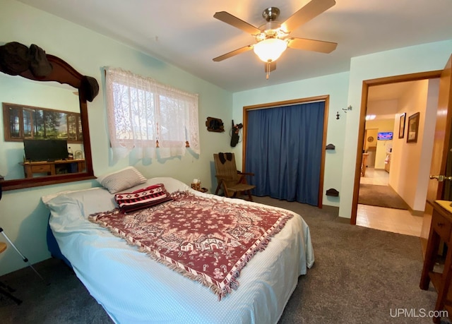 bedroom featuring ceiling fan, dark carpet, and a closet