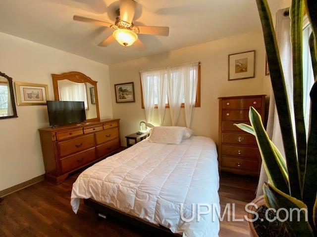 bedroom with ceiling fan and dark hardwood / wood-style flooring