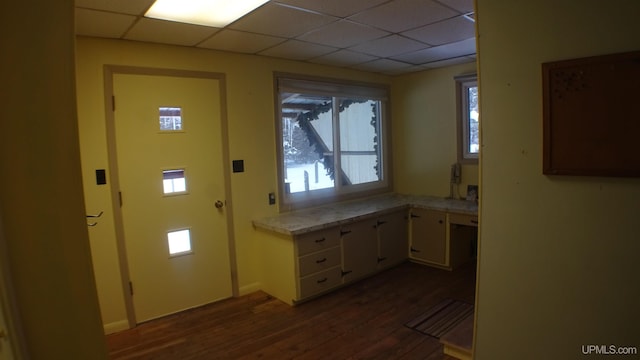 doorway featuring a drop ceiling and dark hardwood / wood-style floors