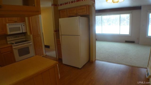 kitchen with white appliances and light hardwood / wood-style flooring