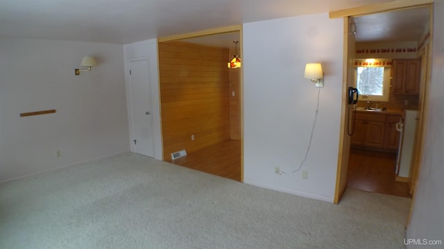 spare room featuring sink and light carpet