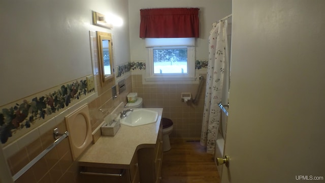 full bathroom featuring vanity, toilet, shower / bath combo with shower curtain, tile walls, and wood-type flooring