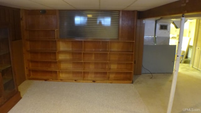 basement with a drop ceiling and carpet