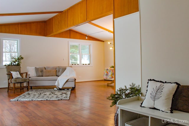 living room featuring vaulted ceiling with beams and hardwood / wood-style floors